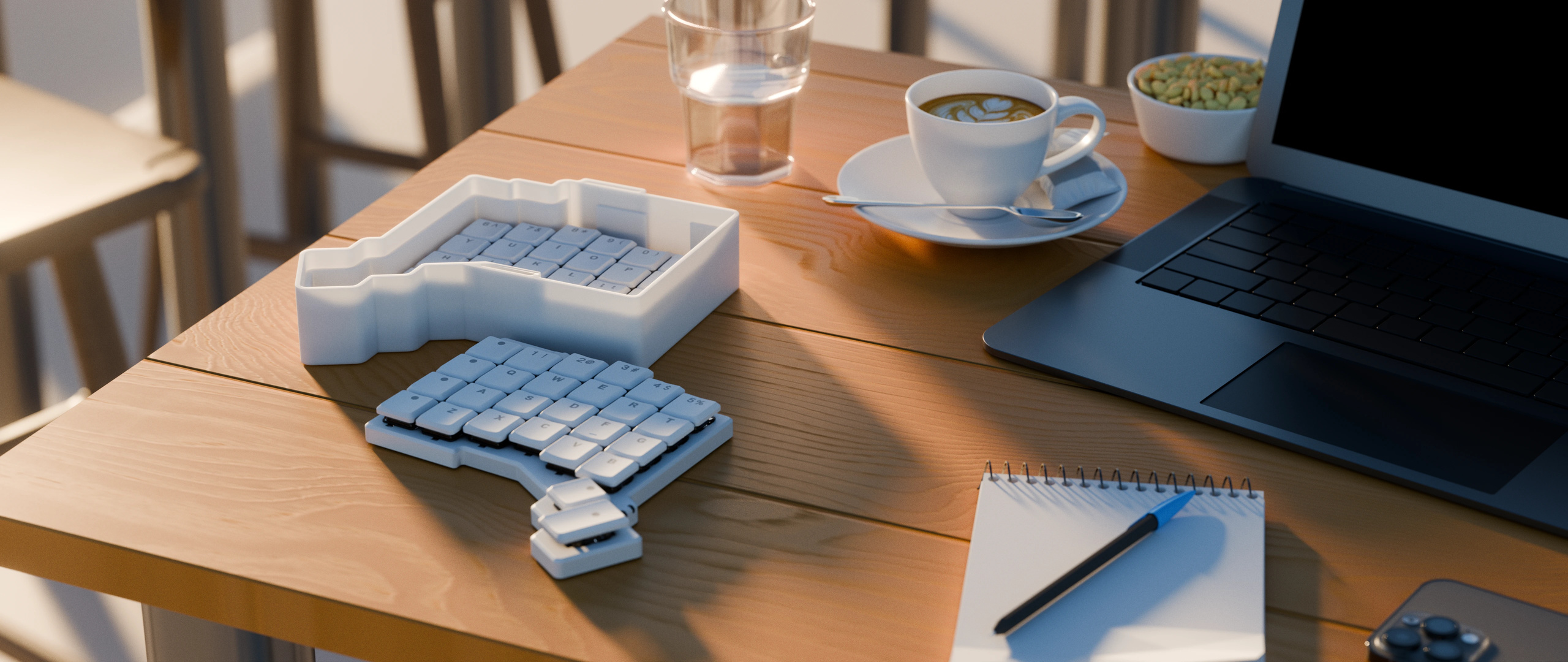 ZSA Voyager keyboard resting inside a 3D-printed minimal travel case on a cafe table